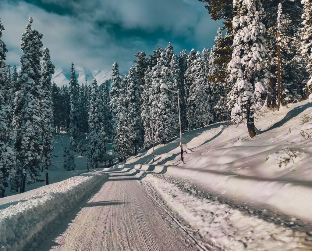 a person riding a snowboard down a snow covered road