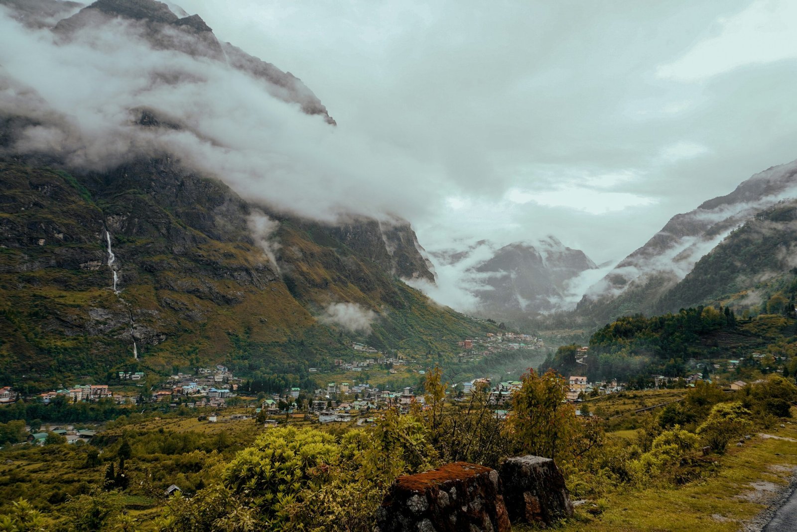 a scenic view of a valley with mountains in the background