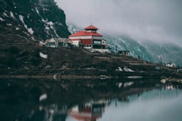 white and red concrete building near body of water